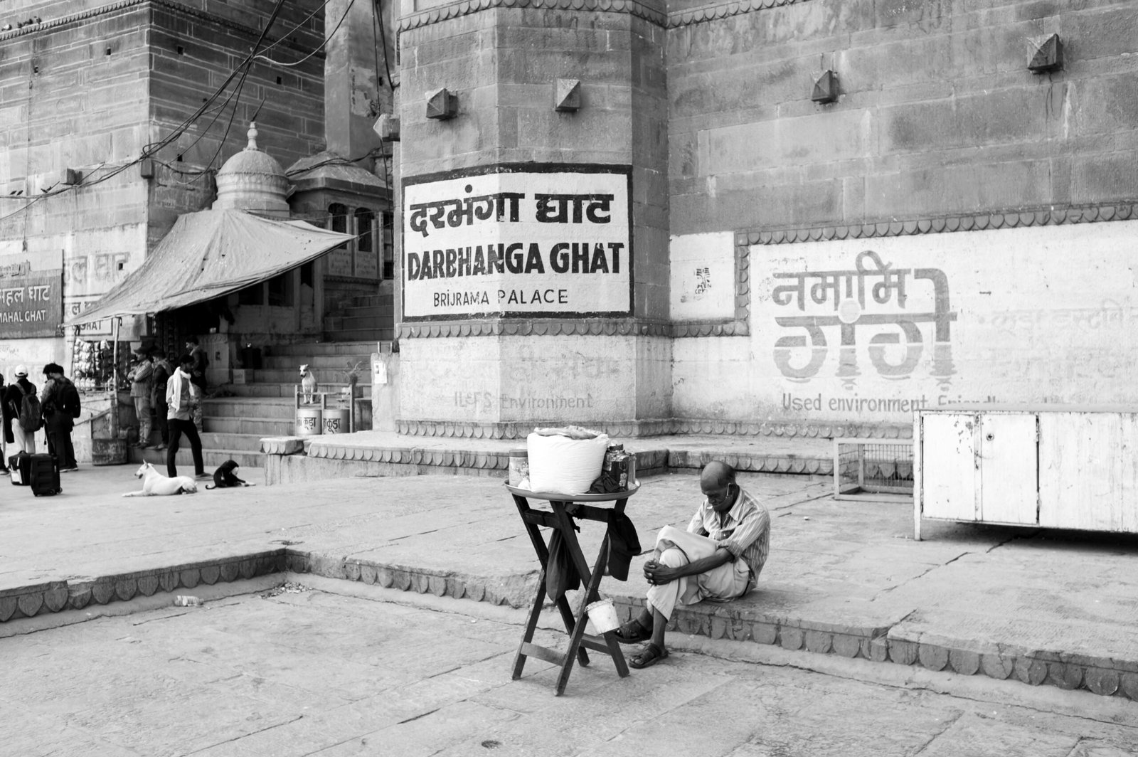 Black and white image capturing daily life at Darbhanga Ghat, Varanasi.