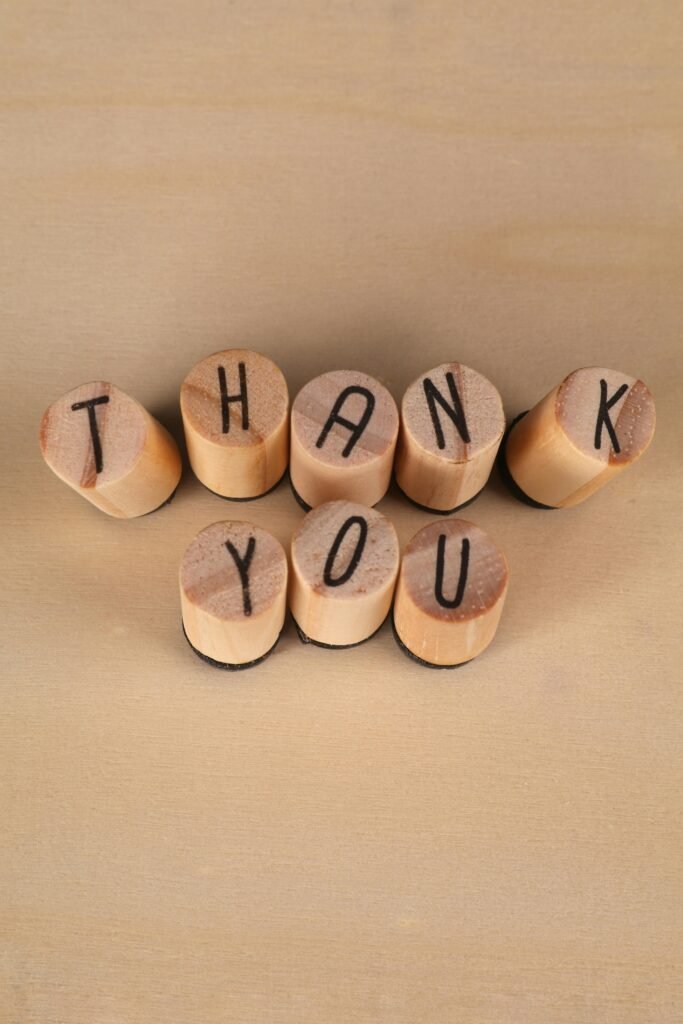 Wooden blocks spelling 'Thank You' arranged on a beige surface. Perfect for gratitude-themed designs.